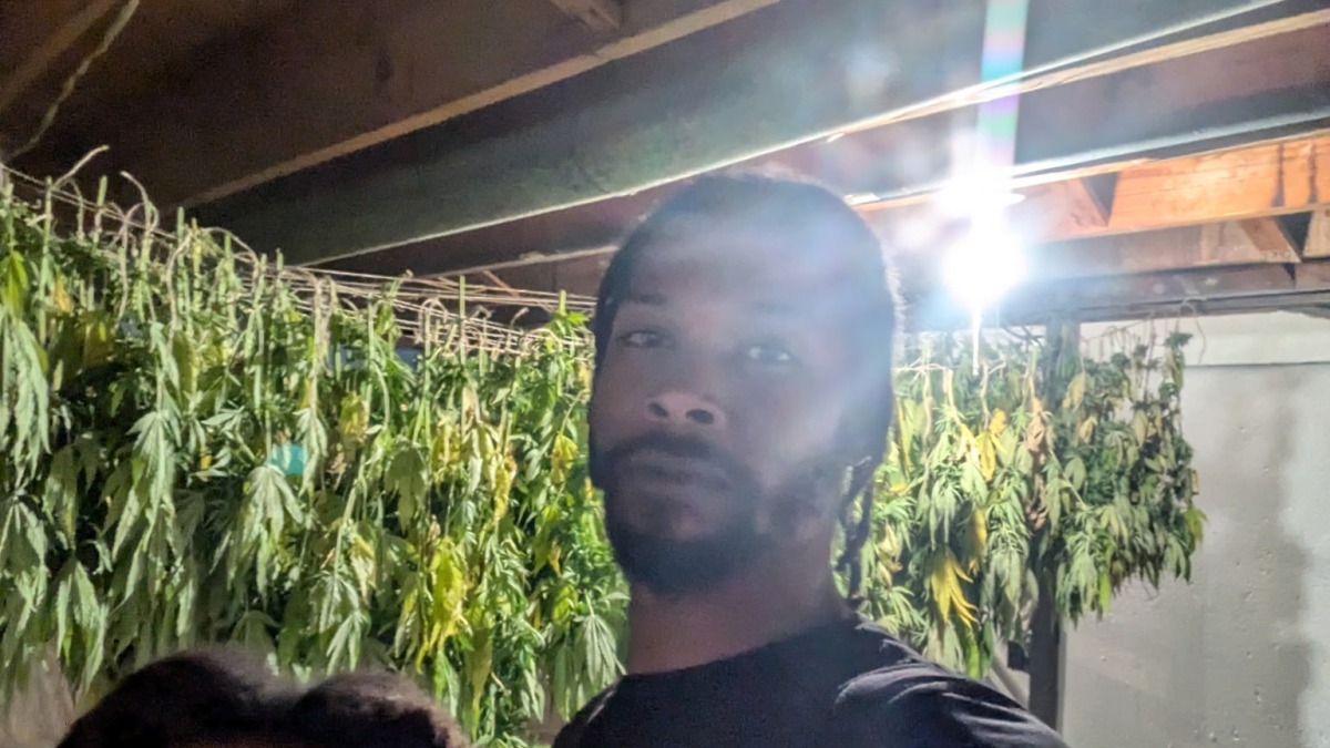 DeVaughn Sr. and Demaaj Brooks posing next to their drying harvest of cannabis from October 4, 2024.
