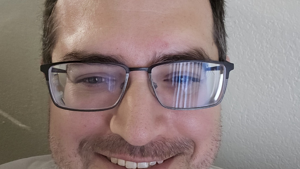 White male, aged in the 40s. Glasses and dark brown hair with sparse grey.