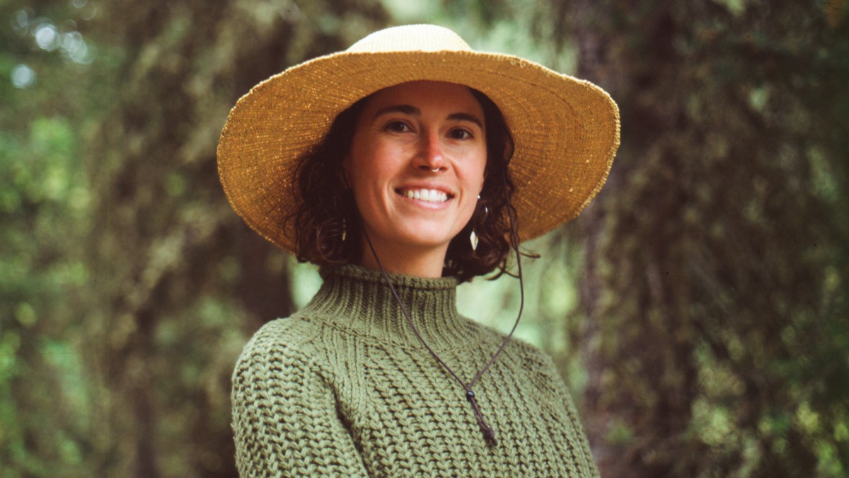 Farmer stands in the forest smiling for a professional shot. 