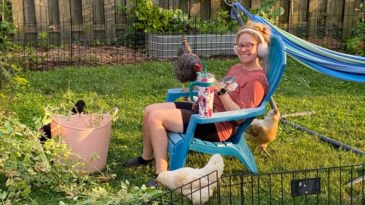 Woman in a chair surrounded by chickens 