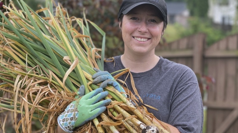 My wife with our garlic haul