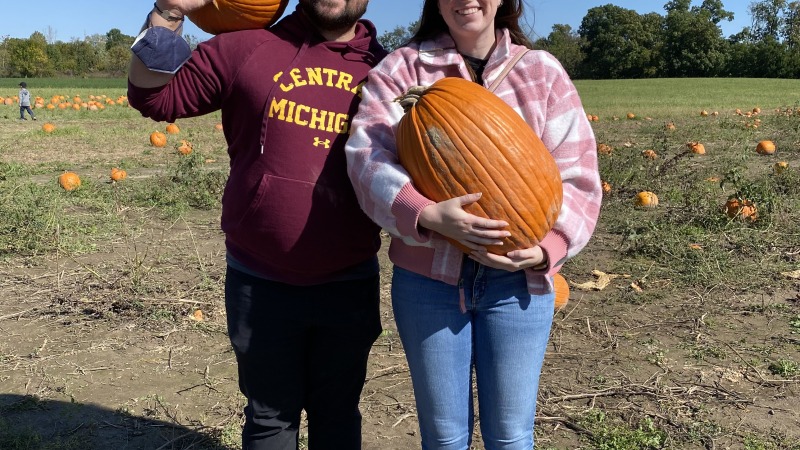 A couple holding pumpkins 