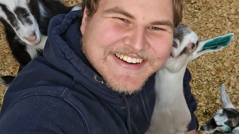 Jeremiah with several goat kids around him