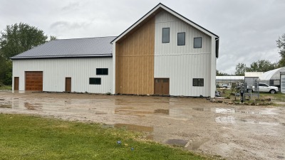 Main building along the busy road front.  Greenhouses and land behind the building.  A beautiful creek and nature trail line the rear property line.