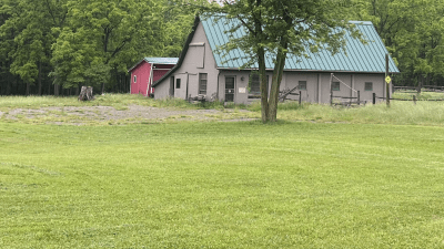 Barn with tack room and 3 stalls, Red shed in back with garage and 3 open bays.